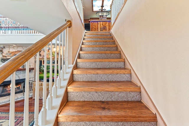 9038 Eagles Vw, Spring Branch, TX 78070 - stairs featuring wood finished floors, a warm lit fireplace, and a towering ceiling