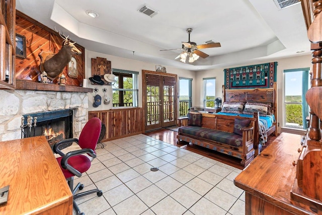 9038 Eagles Vw, Spring Branch, TX 78070 - bedroom with a tray ceiling, tile patterned flooring, access to outside, a stone fireplace, and french doors