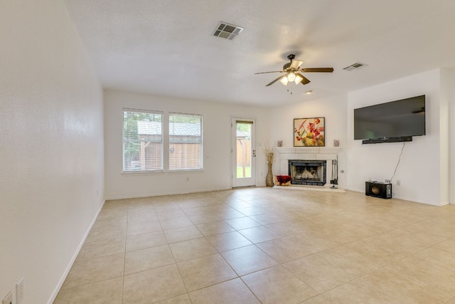 unfurnished living room with a fireplace with raised hearth, a ceiling fan, light tile patterned flooring, and baseboards