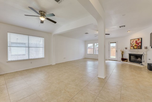 unfurnished living room featuring a ceiling fan, a fireplace with raised hearth, and light tile patterned flooring