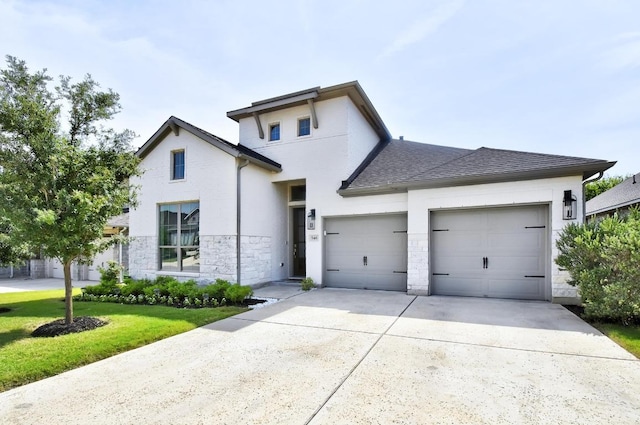 view of front facade with an attached garage, driveway, stone siding, a front lawn, and roof with shingles