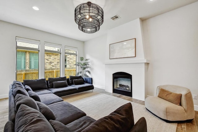 living room featuring wood finished floors, recessed lighting, a fireplace, and baseboards