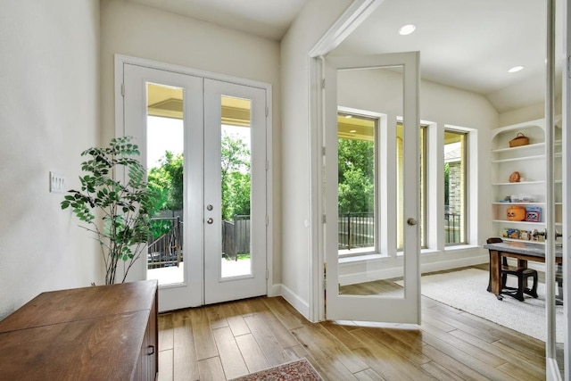 doorway to outside featuring french doors, wood finished floors, baseboards, and recessed lighting