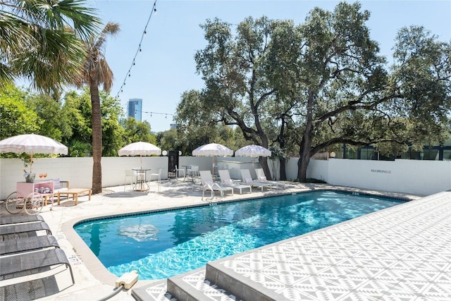 community pool featuring a patio area and a fenced backyard