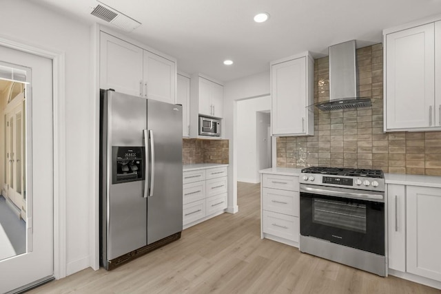 9127 Edwardson Ln, Austin, TX 78749 - kitchen featuring appliances with stainless steel finishes, wall chimney range hood, light countertops, white cabinetry, and recessed lighting