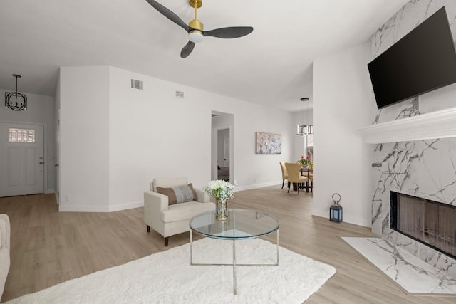 9127 Edwardson Ln, Austin, TX 78749 - living room featuring wood finished floors, a ceiling fan, a fireplace, and plenty of natural light