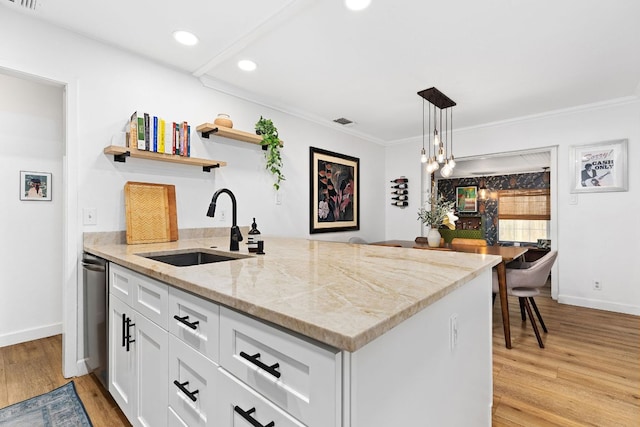 kitchen with a sink, open shelves, white cabinets, light wood-style flooring, and baseboards