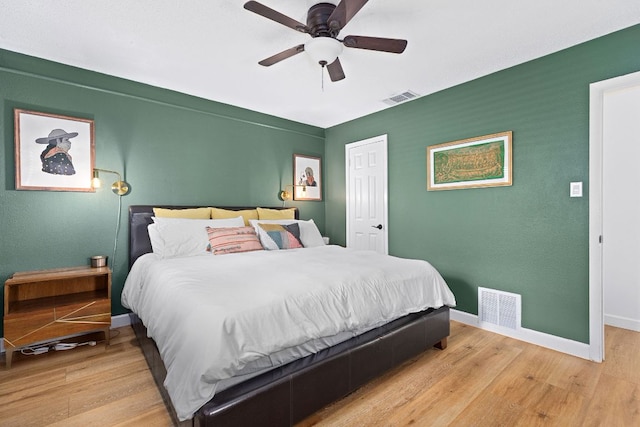 bedroom featuring light wood-style flooring, baseboards, and a ceiling fan