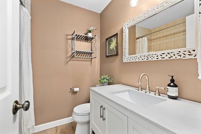 bathroom with toilet, wood finished floors, vanity, baseboards, and a shower with shower curtain