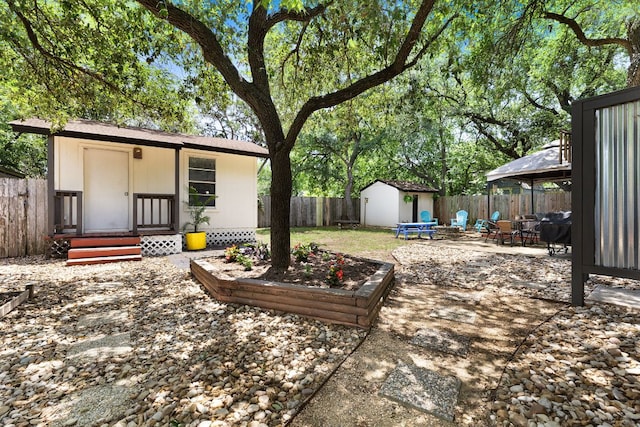 fenced backyard with an outdoor structure, a patio area, and a storage unit