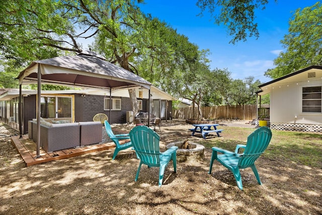view of yard featuring fence, a gazebo, and an outdoor living space with a fire pit