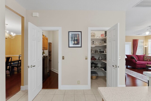 8105 Red Bird Ct, Austin, TX 78726 - hall featuring light tile patterned floors and a chandelier