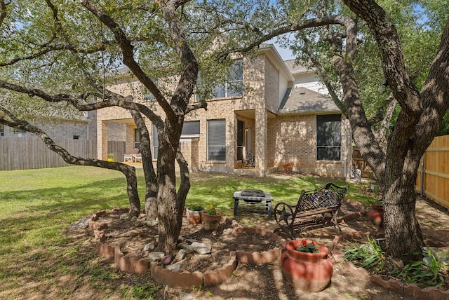8105 Red Bird Ct, Austin, TX 78726 - back of property featuring brick siding, a fenced backyard, and an outdoor fire pit