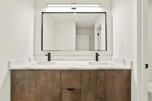 full bath featuring double vanity and toilet