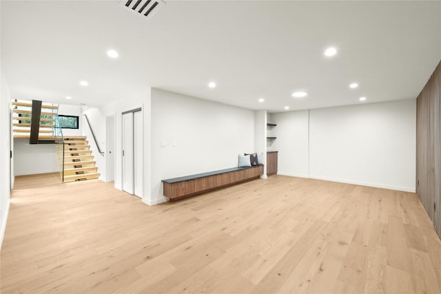 basement with stairway, recessed lighting, light wood finished floors, and baseboards