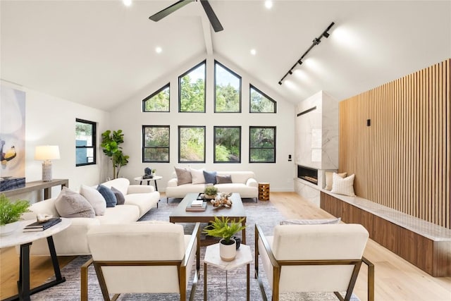620 Bermuda St, Lakeway, TX 78734 - living room featuring light wood-style floors, a ceiling fan, a premium fireplace, high vaulted ceiling, and beamed ceiling