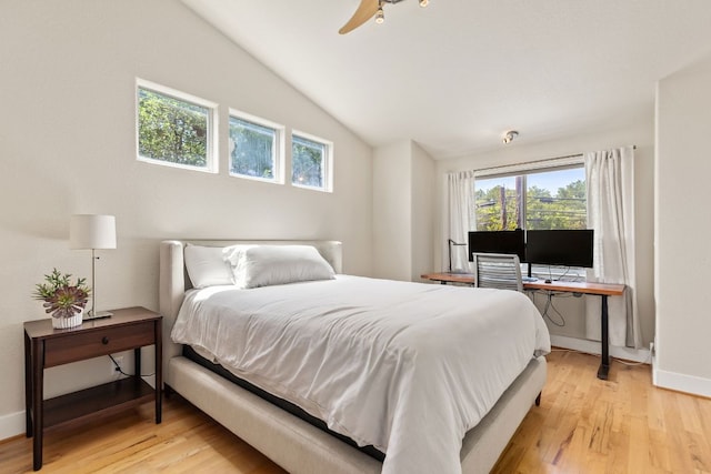 bedroom with vaulted ceiling, light wood-style flooring, and baseboards