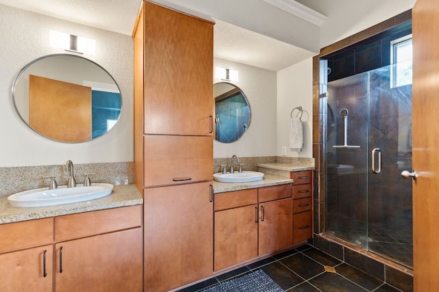 bathroom with a shower stall, tile patterned floors, and two vanities