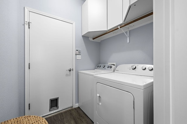 laundry room featuring cabinet space, washer and dryer, dark wood-type flooring, and baseboards
