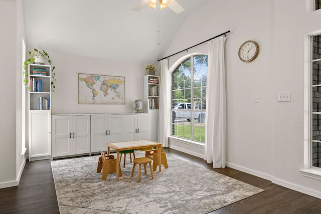 dining space featuring vaulted ceiling, dark wood-style flooring, baseboards, and a ceiling fan