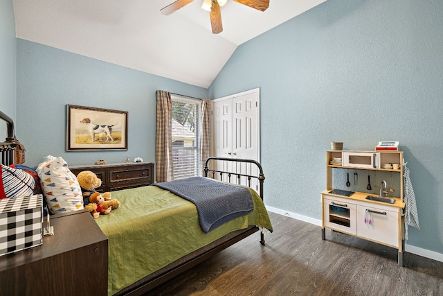 bedroom featuring lofted ceiling, dark wood-style floors, baseboards, a ceiling fan, and a closet