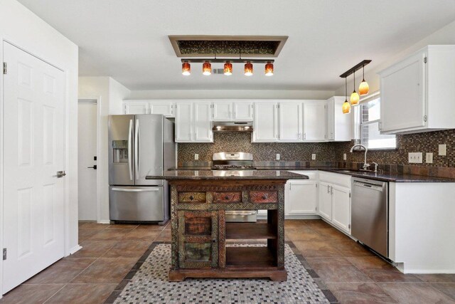 2912 Sydney Dr, Austin, TX 78728 - kitchen with stainless steel appliances, under cabinet range hood, dark countertops, backsplash, and white cabinets