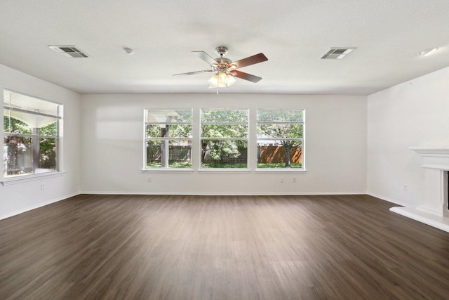 2912 Sydney Dr, Austin, TX 78728 - spare room with dark wood-style flooring, ceiling fan, baseboards, and a fireplace with raised hearth