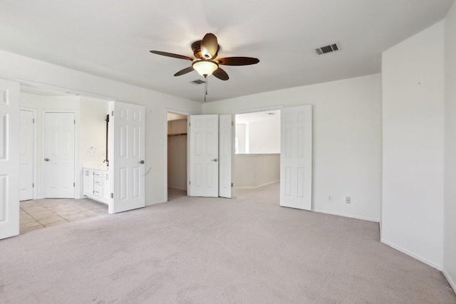 2912 Sydney Dr, Austin, TX 78728 - unfurnished bedroom with light carpet, a spacious closet, connected bathroom, and a ceiling fan