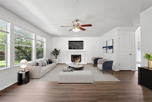 2912 Sydney Dr, Austin, TX 78728 - living room featuring healthy amount of natural light, wood finished floors, a ceiling fan, and a fireplace with raised hearth