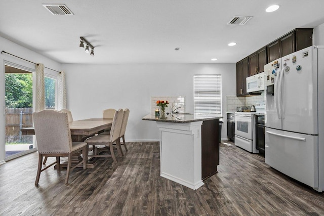 607 Big Bend Trl, Taylor, TX 76574 - kitchen with white appliances, dark brown cabinets, dark wood-style floors, tasteful backsplash, and recessed lighting
