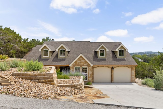 cape cod home with stone siding, driveway, and roof with shingles