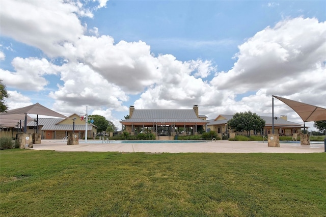 view of property's community featuring a lawn and a swimming pool