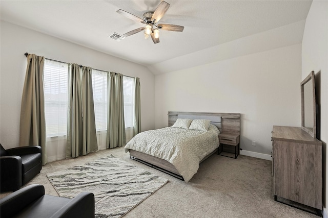 bedroom featuring light colored carpet, lofted ceiling, baseboards, and ceiling fan