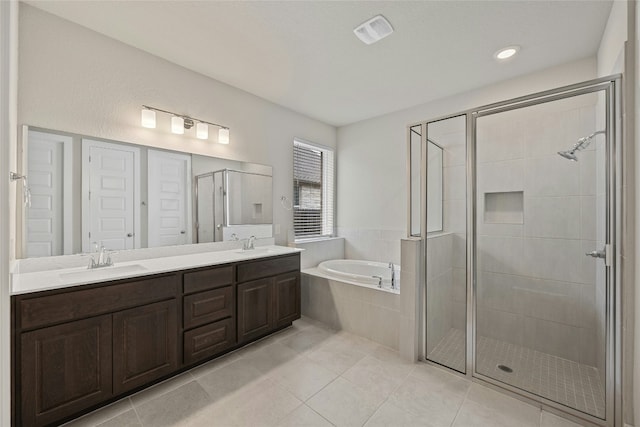 bathroom with a bath, a stall shower, tile patterned flooring, and double vanity