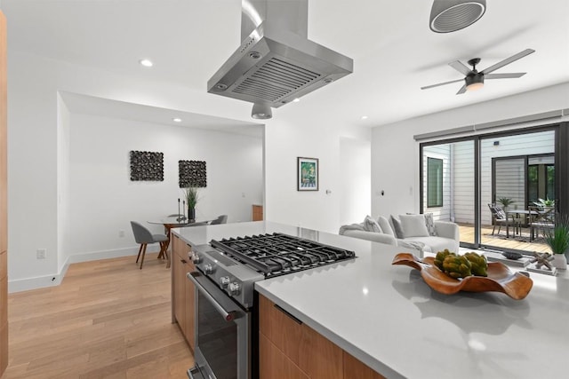 2003 Karen Ave Unit A, Austin, TX 78757 - kitchen with gas stove, island range hood, light wood-style flooring, open floor plan, and light countertops