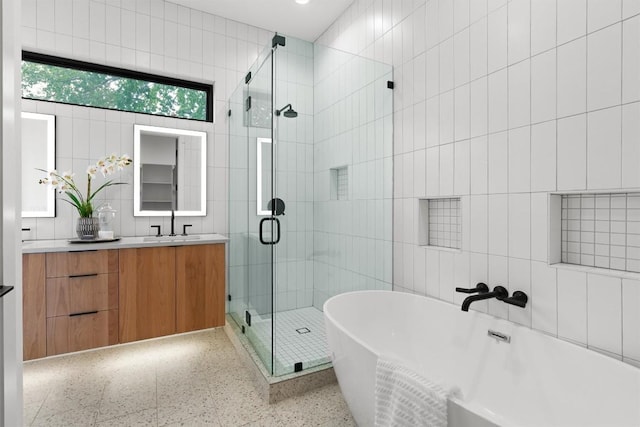2003 Karen Ave Unit A, Austin, TX 78757 - bathroom with tile walls, speckled floor, a freestanding tub, vanity, and a stall shower