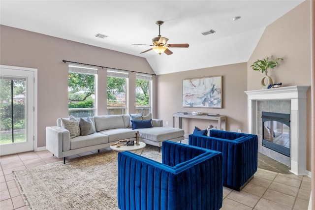 2415 Arbor Dr, Round Rock, TX 78681 - living area with light tile patterned floors, a ceiling fan, a tiled fireplace, lofted ceiling, and baseboards