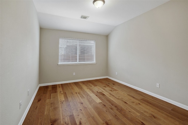 2415 Arbor Dr, Round Rock, TX 78681 - spare room featuring wood finished floors, baseboards, and lofted ceiling