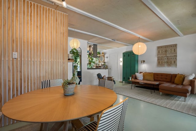 dining area with finished concrete flooring and beam ceiling