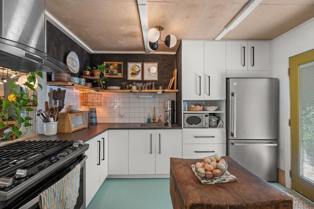 kitchen featuring stainless steel appliances, a sink, range hood, open shelves, and decorative backsplash