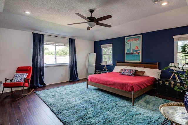6018 Abilene Trl, Austin, TX 78749 - bedroom with multiple windows, a textured ceiling, wood finished floors, and ceiling fan