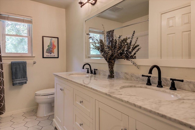 6018 Abilene Trl, Austin, TX 78749 - bathroom featuring toilet, double vanity, baseboards, a shower, and tile patterned floors