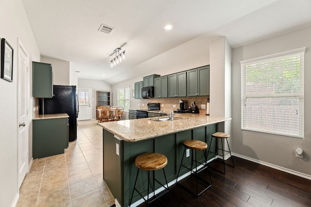 200 Circle Way Unit 8E, Jarrell, TX 76537 - kitchen with black appliances, lofted ceiling, a peninsula, decorative backsplash, and a sink