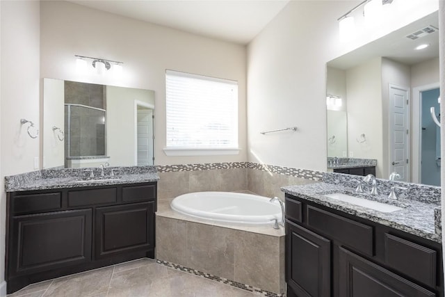 2713 Margarita Ct, Round Rock, TX 78665 - full bath featuring a garden tub, a shower stall, two vanities, and tile patterned floors