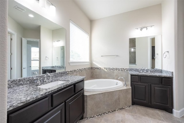 2713 Margarita Ct, Round Rock, TX 78665 - full bathroom with a garden tub, two vanities, and tile patterned flooring