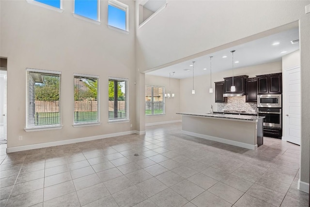 2713 Margarita Ct, Round Rock, TX 78665 - kitchen with stainless steel appliances, open floor plan, plenty of natural light, light tile patterned floors, and a towering ceiling