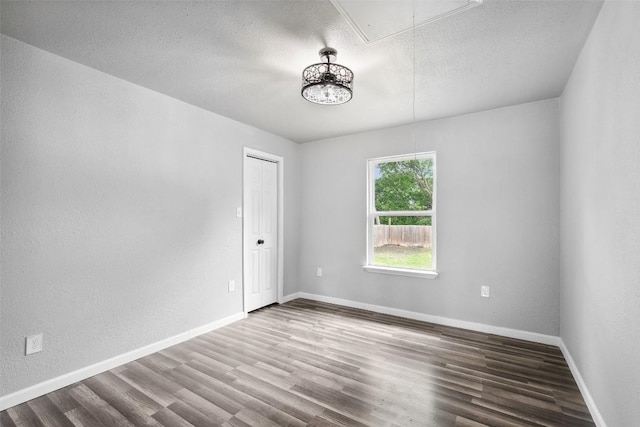 7000 Carwill Dr, Austin, TX 78724 - empty room featuring attic access, wood finished floors, a textured ceiling, baseboards, and a textured wall