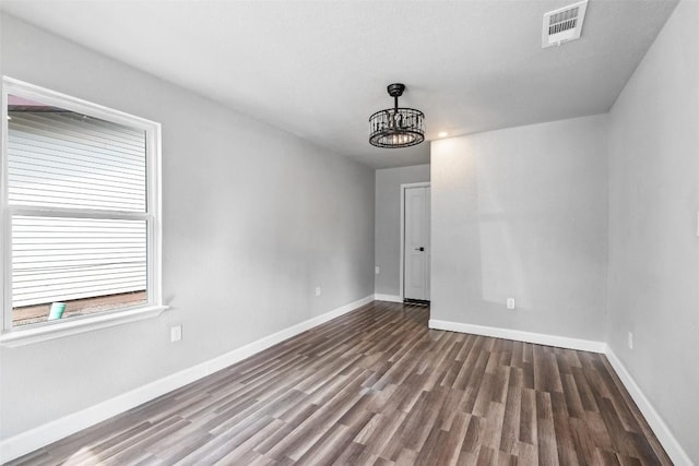 7000 Carwill Dr, Austin, TX 78724 - empty room featuring a chandelier, wood finished floors, and baseboards