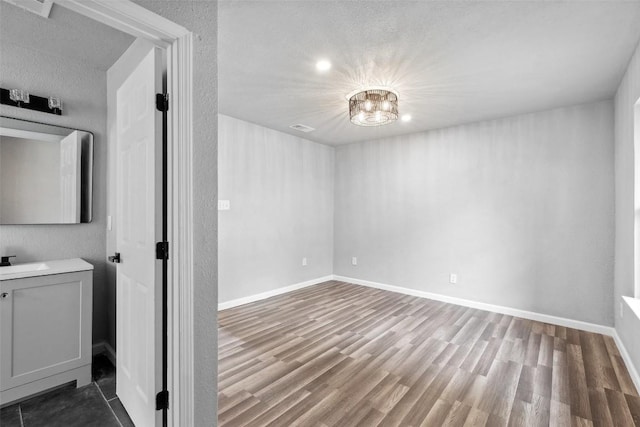 7000 Carwill Dr, Austin, TX 78724 - unfurnished bedroom featuring wood finished floors, a sink, and baseboards