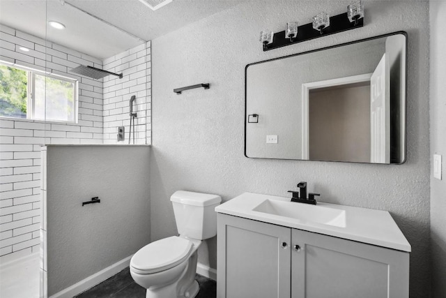 7000 Carwill Dr, Austin, TX 78724 - bathroom with tiled shower, vanity, toilet, and a textured wall